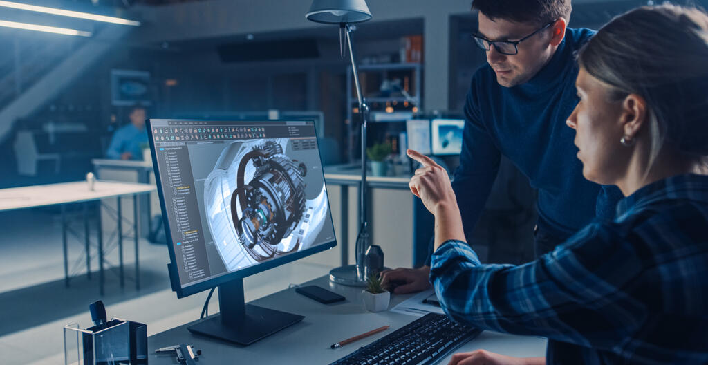 A man and woman looking at a computer-generated 3D model of a jet engine
