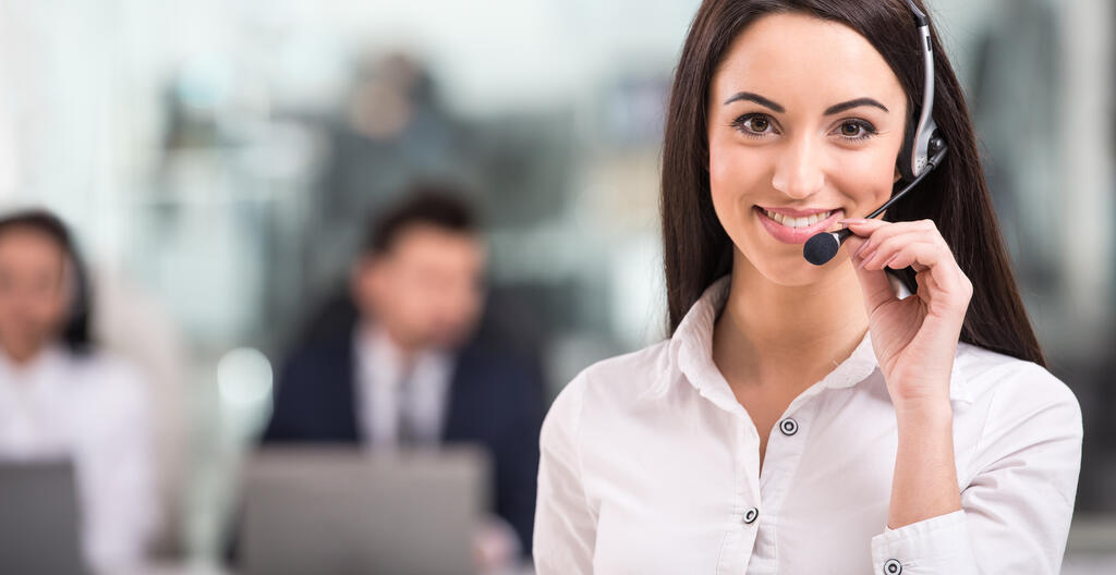 Woman wearing a headset smiling and holding a microphone