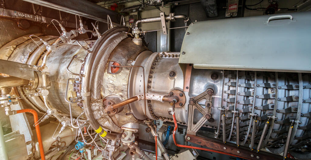 Gas turbine engine of feed gas compressor located inside pressurized enclosure, The gas turbine engine used in offshore oil and gas central processing platform.