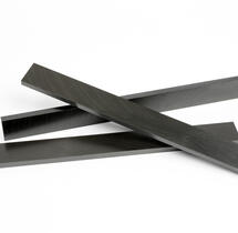 Three black liners and pads made from high performance polymerspositioned on a white surface, demonstrating temperature performance with high-performance polymers.