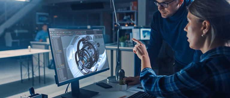 A man and woman looking at a computer-generated 3D model of a jet engine