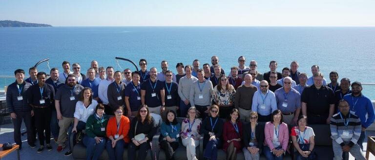 A group of people standing on the shore line representing the Omniseal Solutions Capture Team