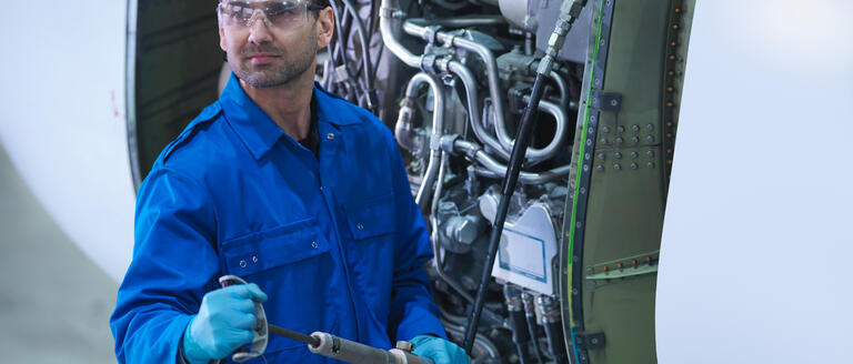 Aerospace engineer checking for leaks in an aviation engine